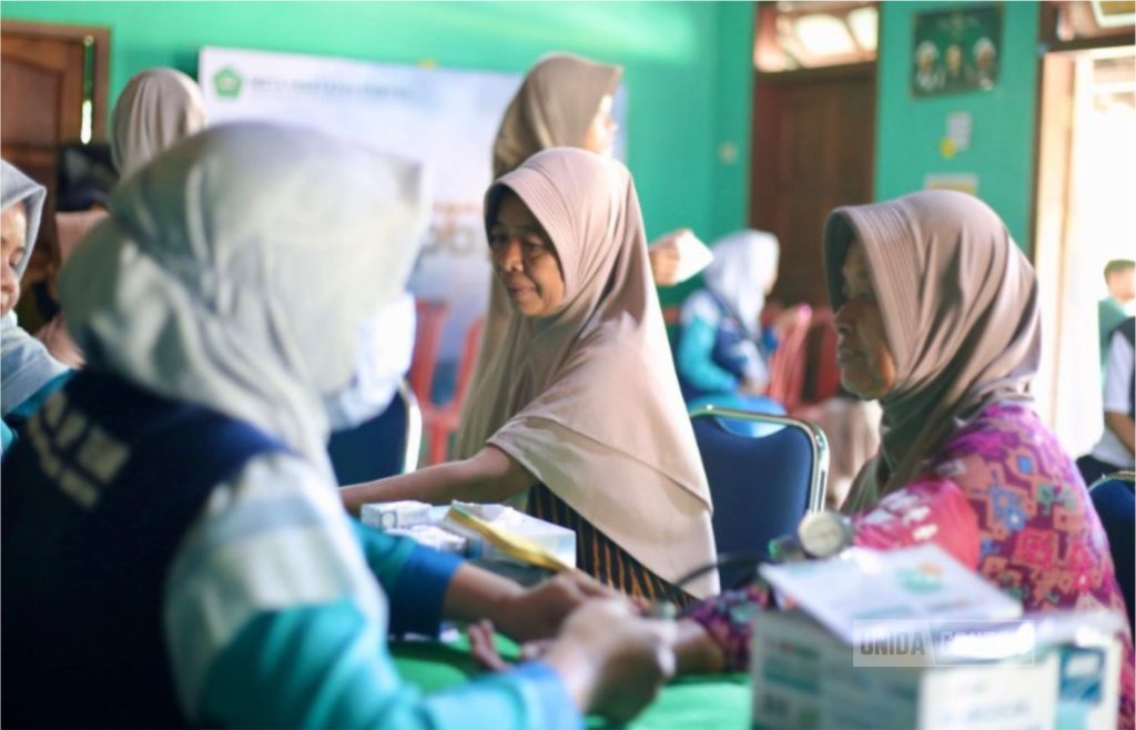 Petugas medis dan mahasiswa Universitas Islam Terbaik melayani pemeriksaan kesehatan gratis warga Desa Ngindeng dalam kegiatan Bakti Sosial 2025.