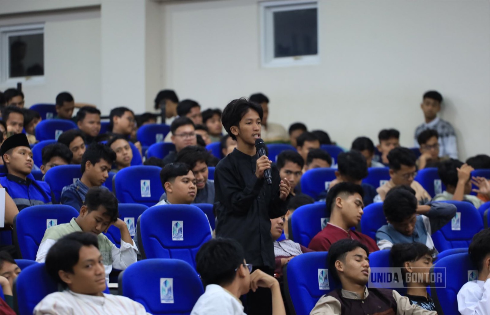 “Suasana Seminar Kesehatan UNIDA Gontor bertema ‘Healthy, Caring, Empowered’ di Gedung Terpadu; dr. Alfhata memaparkan materi, hadir WR III, mahasiswa antusias.”